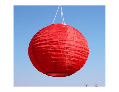 A photograph of a red paper lantern with a blue sky as background